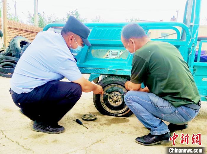 賽旦與民警共同維修三輪摩托車?！∫懒窘?攝