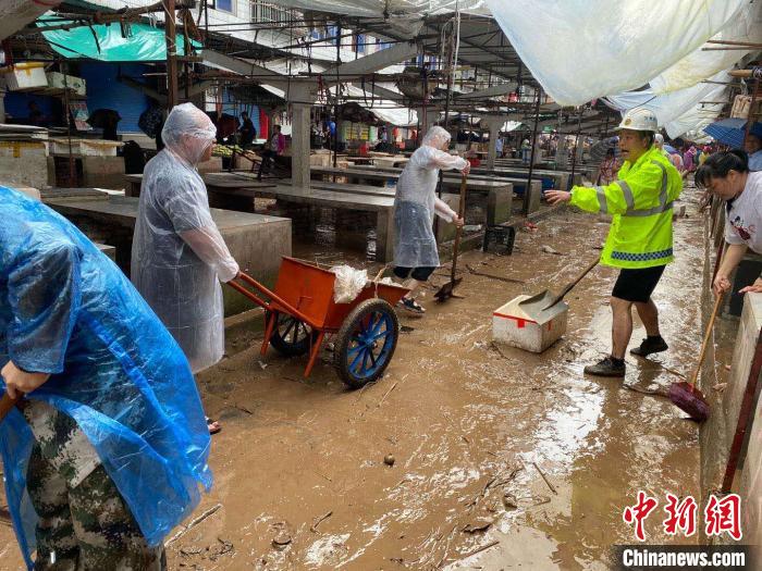 圖為7月26日，暴雨引發(fā)的洪水過境后，重慶萬州區(qū)分水鎮(zhèn)政府干部職工及志愿者清掃淤泥和垃圾?！　≈貞c萬州區(qū)委宣傳部供圖 攝